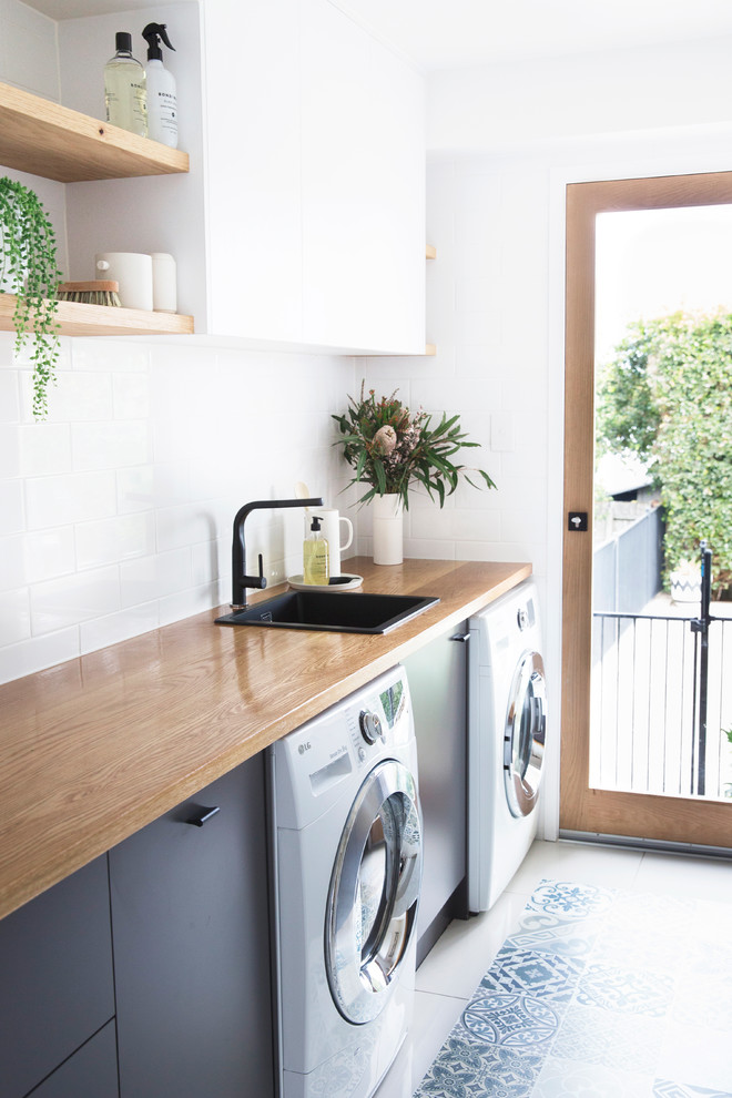 Foto de lavadero moderno con fregadero encastrado, paredes blancas, suelo vinílico y lavadora y secadora juntas