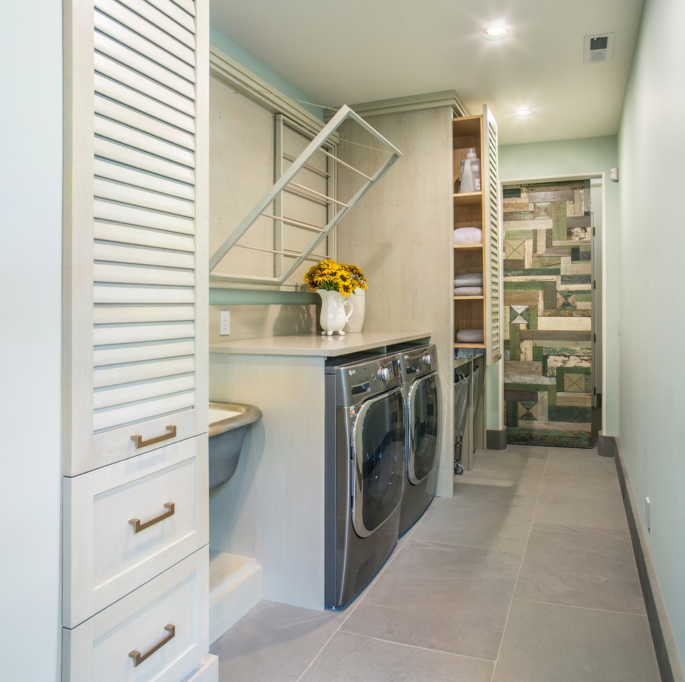 Example of a mid-sized transitional single-wall dedicated laundry room design in Seattle with an utility sink, louvered cabinets, quartz countertops, green walls and a side-by-side washer/dryer