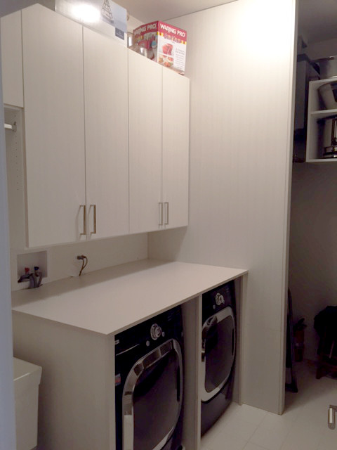 Immagine di una lavanderia multiuso contemporanea di medie dimensioni con ante lisce, ante in legno chiaro e pareti beige