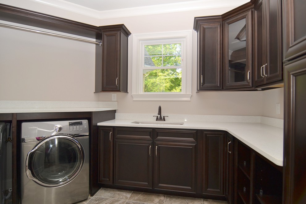 Design ideas for a large classic u-shaped utility room in Raleigh with recessed-panel cabinets, dark wood cabinets, beige walls, ceramic flooring and a side by side washer and dryer.