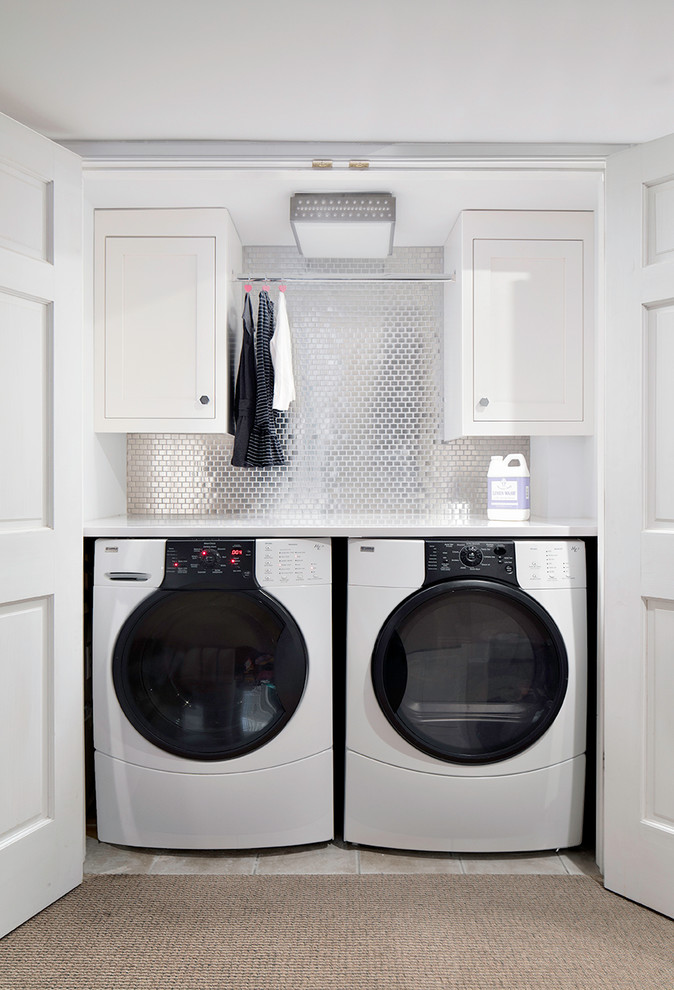 This is an example of a classic utility room in New York with white cabinets, a side by side washer and dryer and white worktops.