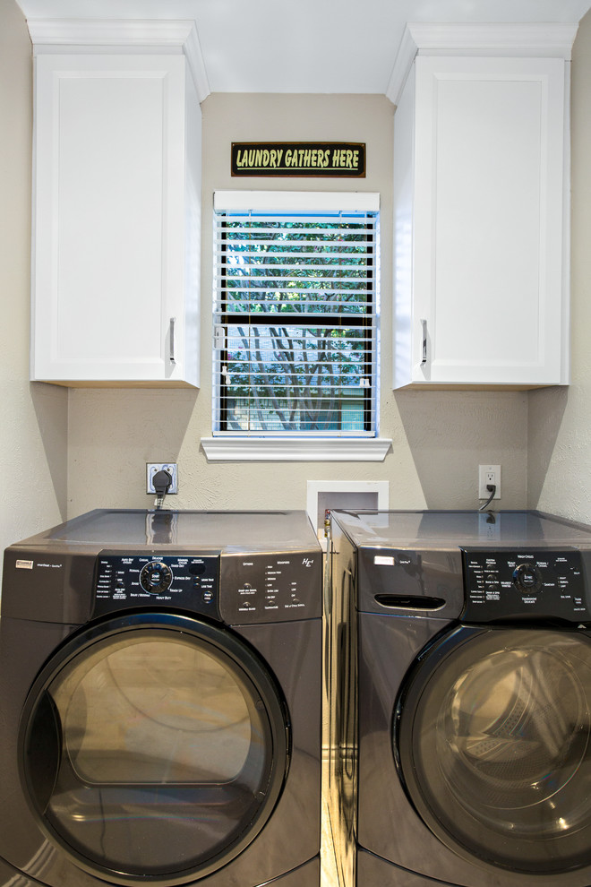 Immagine di una lavanderia multiuso minimal di medie dimensioni con ante lisce, ante bianche, top in quarzo composito, pareti grigie, pavimento in gres porcellanato, lavatrice e asciugatrice affiancate e pavimento beige