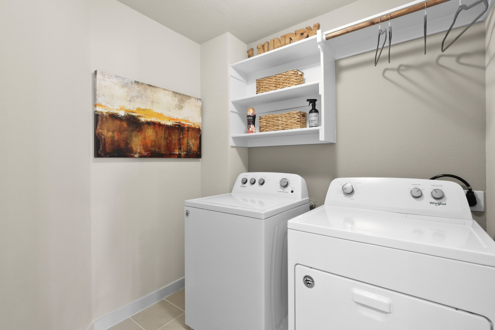 Imagen de cuarto de lavado costero de tamaño medio con suelo de baldosas de cerámica y suelo beige