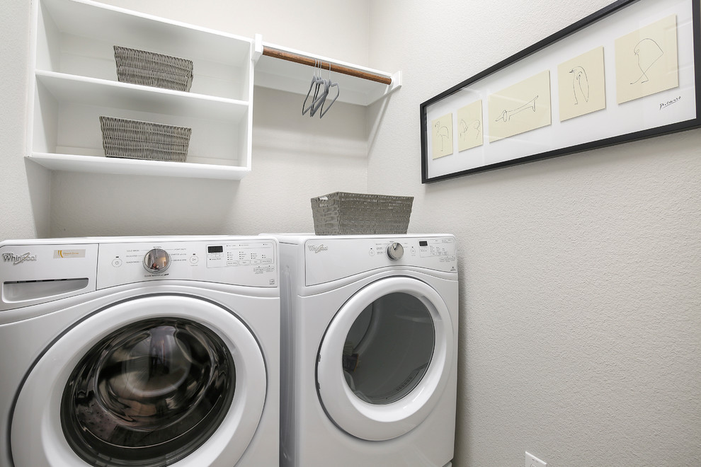 Einzeilige, Kleine Moderne Waschküche mit offenen Schränken, weißen Schränken, beiger Wandfarbe und Waschmaschine und Trockner nebeneinander in Dallas