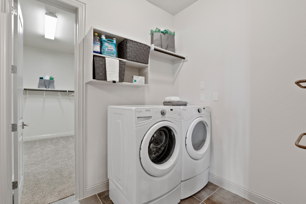 Esempio di una sala lavanderia minimal di medie dimensioni con nessun'anta, ante bianche, pareti beige, pavimento con piastrelle in ceramica, lavatrice e asciugatrice affiancate e pavimento beige