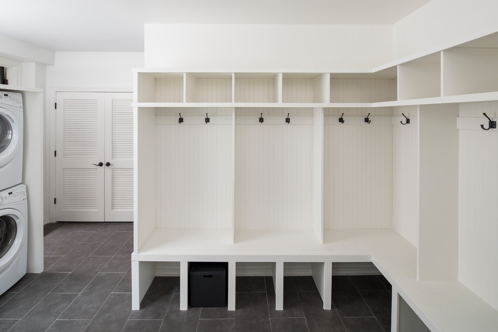 Large country utility room in Chicago with white walls, porcelain flooring and a stacked washer and dryer.
