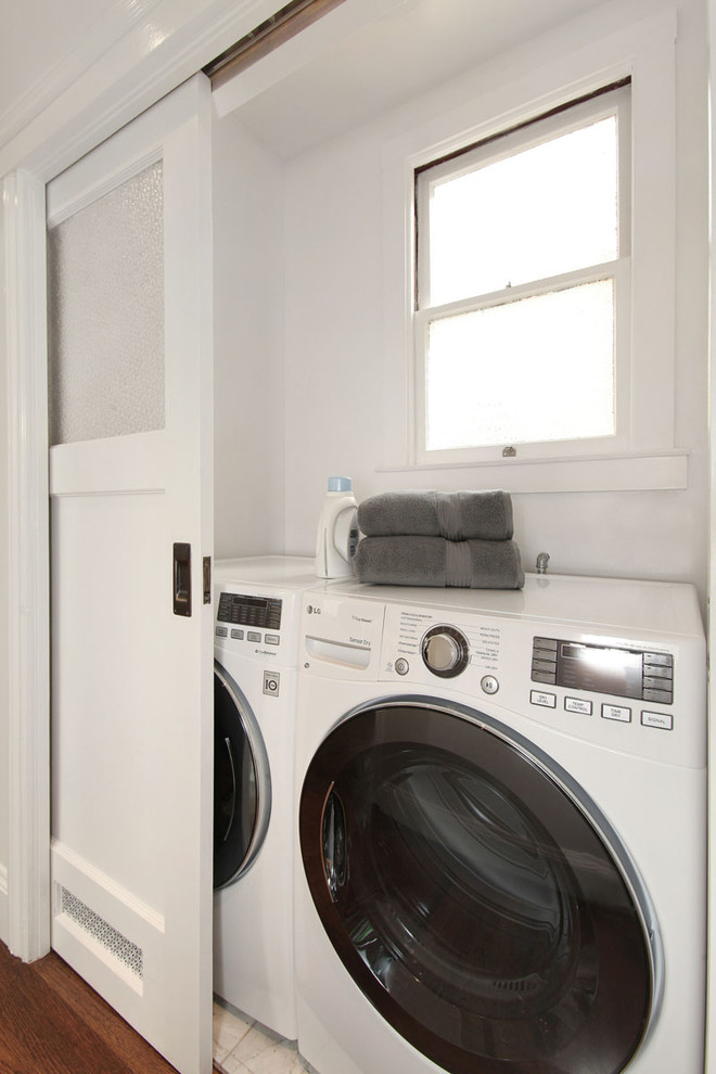 Diseño de armario lavadero contemporáneo pequeño con lavadora y secadora juntas, paredes blancas, suelo de baldosas de cerámica y suelo beige