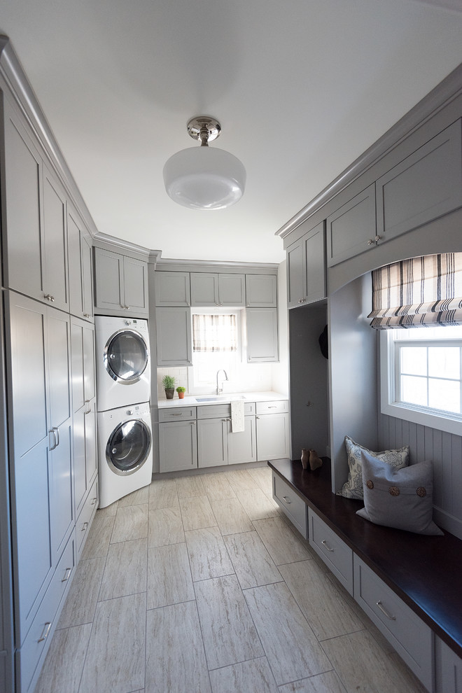 Exempel på en stor klassisk vita l-formad vitt tvättstuga enbart för tvätt, med luckor med infälld panel, grå skåp, granitbänkskiva, ljust trägolv och brunt golv