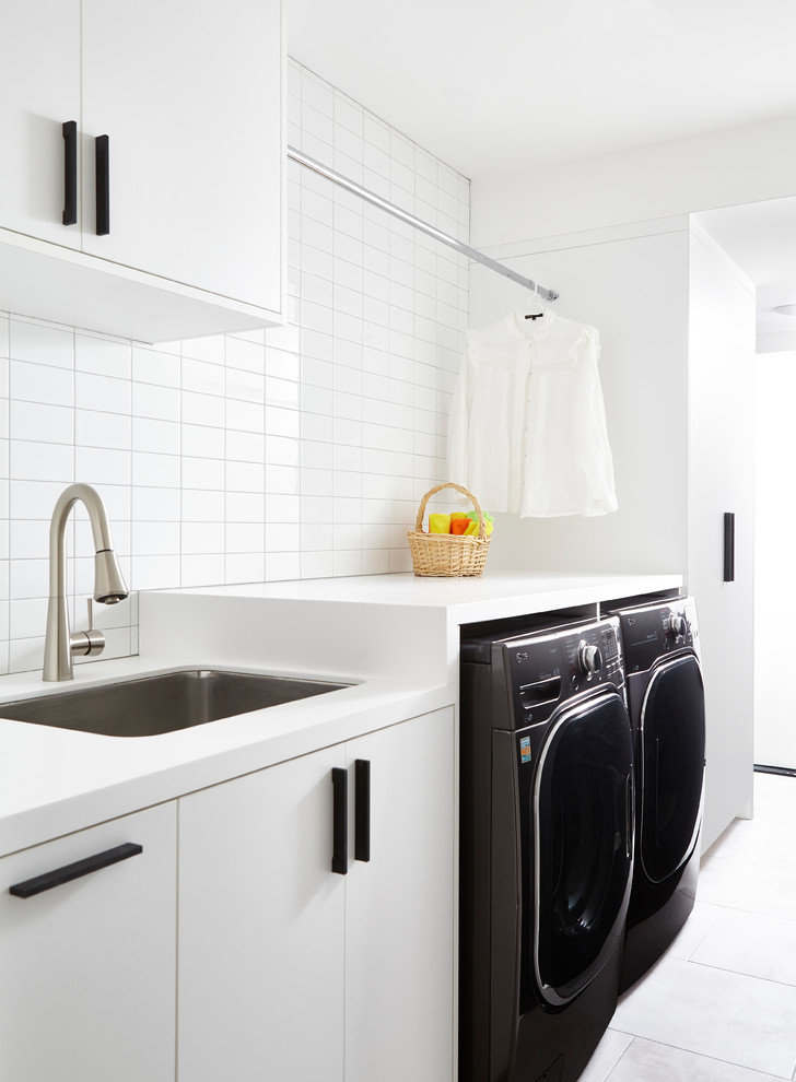Einzeilige Moderne Waschküche mit Waschbecken, flächenbündigen Schrankfronten, weißen Schränken, weißer Wandfarbe, Waschmaschine und Trockner nebeneinander und weißer Arbeitsplatte in Toronto