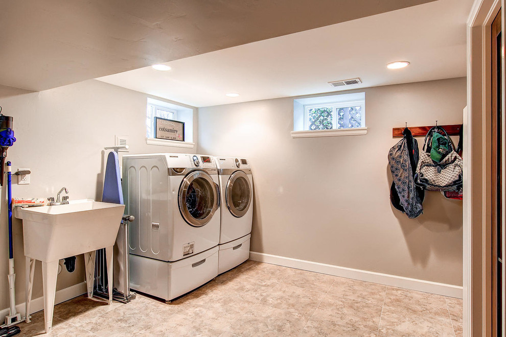 Zweizeilige, Große Moderne Waschküche mit Ausgussbecken, beiger Wandfarbe, Keramikboden und Waschmaschine und Trockner nebeneinander in Denver