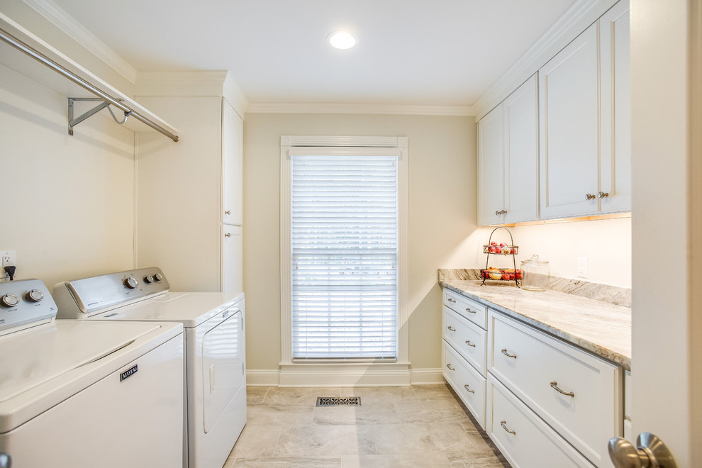 Klassisk inredning av en mellanstor flerfärgade parallell flerfärgat tvättstuga enbart för tvätt, med luckor med infälld panel, vita skåp, marmorbänkskiva, grå väggar, klinkergolv i porslin, en tvättmaskin och torktumlare bredvid varandra och grått golv