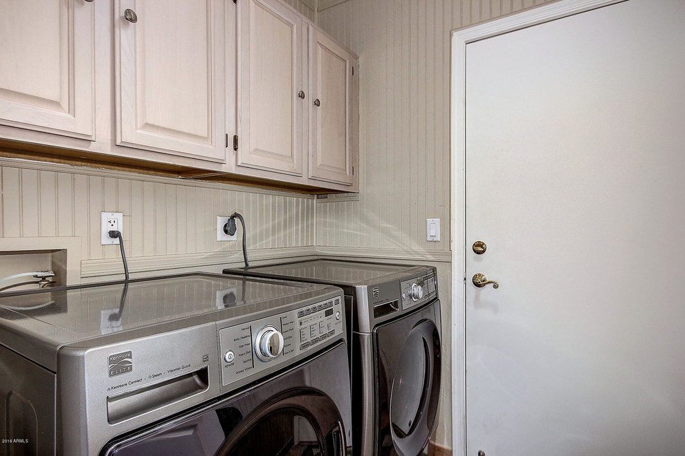 フェニックスにある中くらいな地中海スタイルのおしゃれな洗濯室 (ll型、レイズドパネル扉のキャビネット、淡色木目調キャビネット、左右配置の洗濯機・乾燥機) の写真