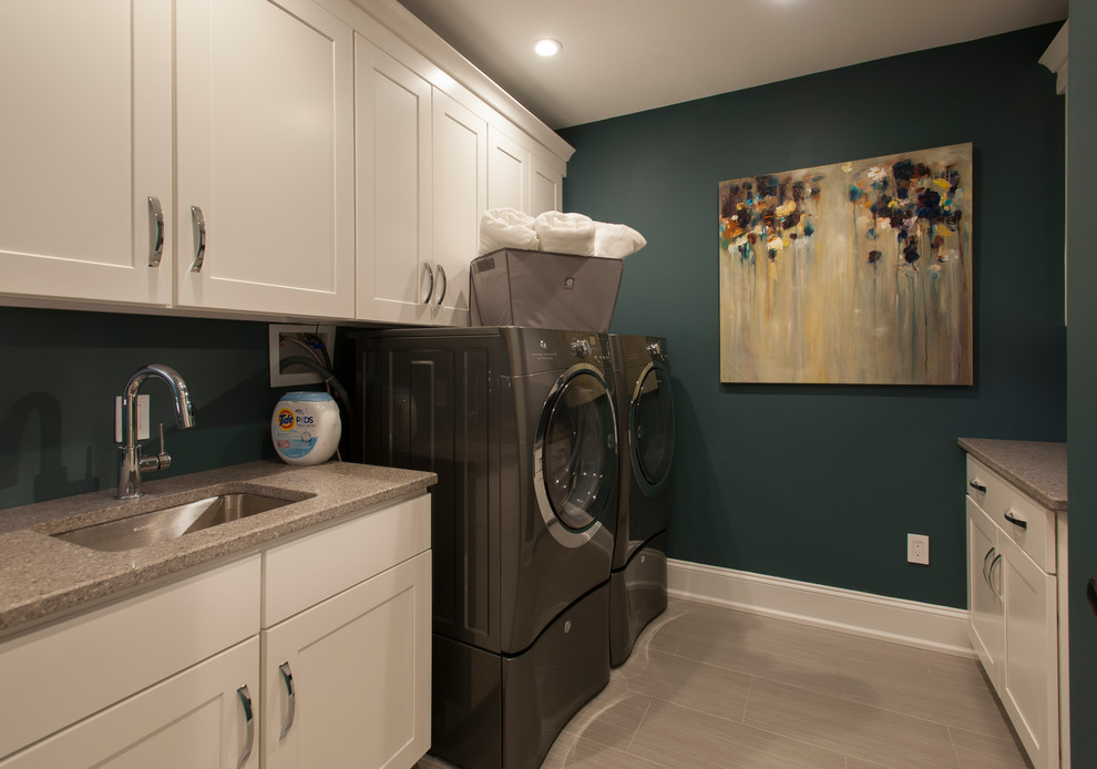Example of a large trendy galley porcelain tile and gray floor utility room design in Philadelphia with an undermount sink, shaker cabinets, white cabinets, a side-by-side washer/dryer and blue walls