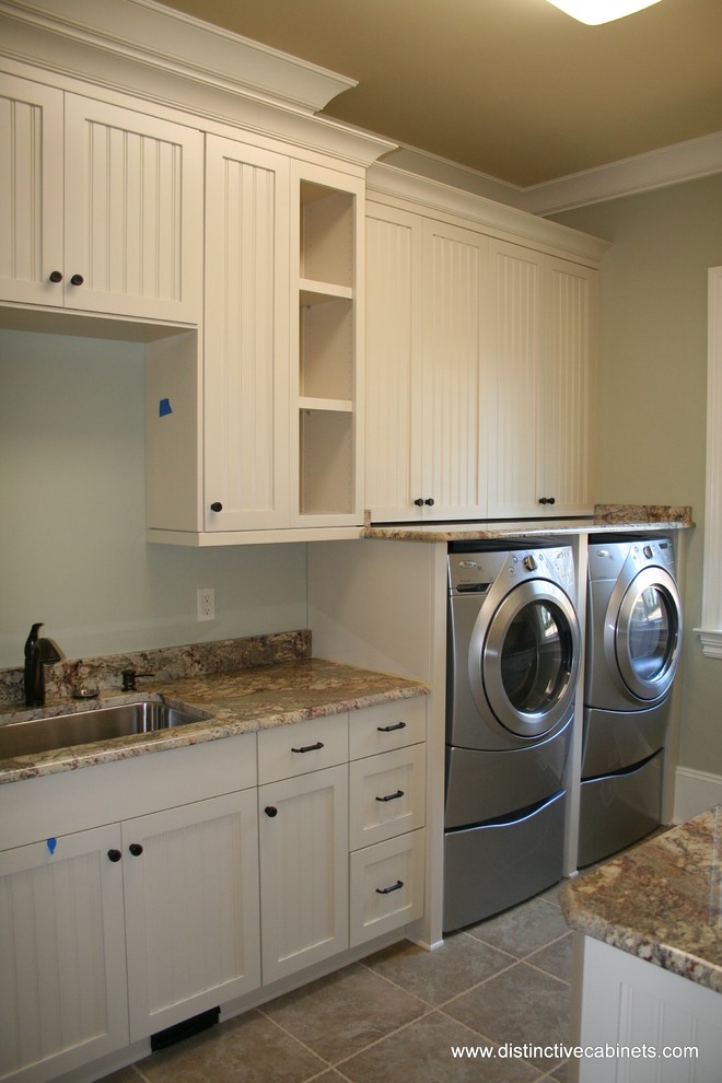 Classic utility room in Charlotte with recessed-panel cabinets, white cabinets and a side by side washer and dryer.