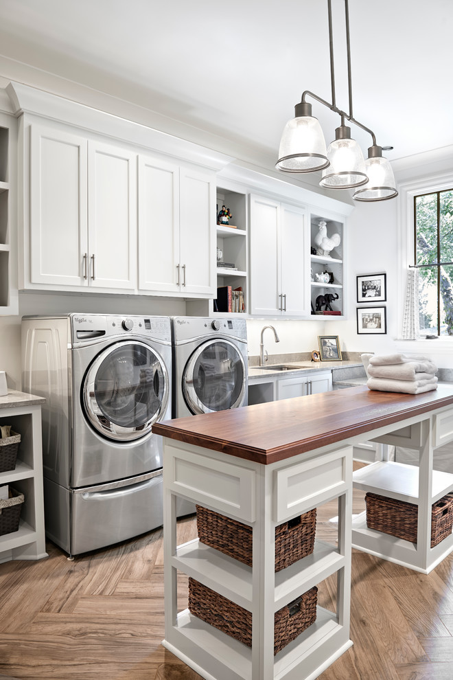 Example of a large transitional l-shaped slate floor utility room design in Nashville with a single-bowl sink, shaker cabinets, white cabinets, limestone countertops, white walls and a side-by-side washer/dryer