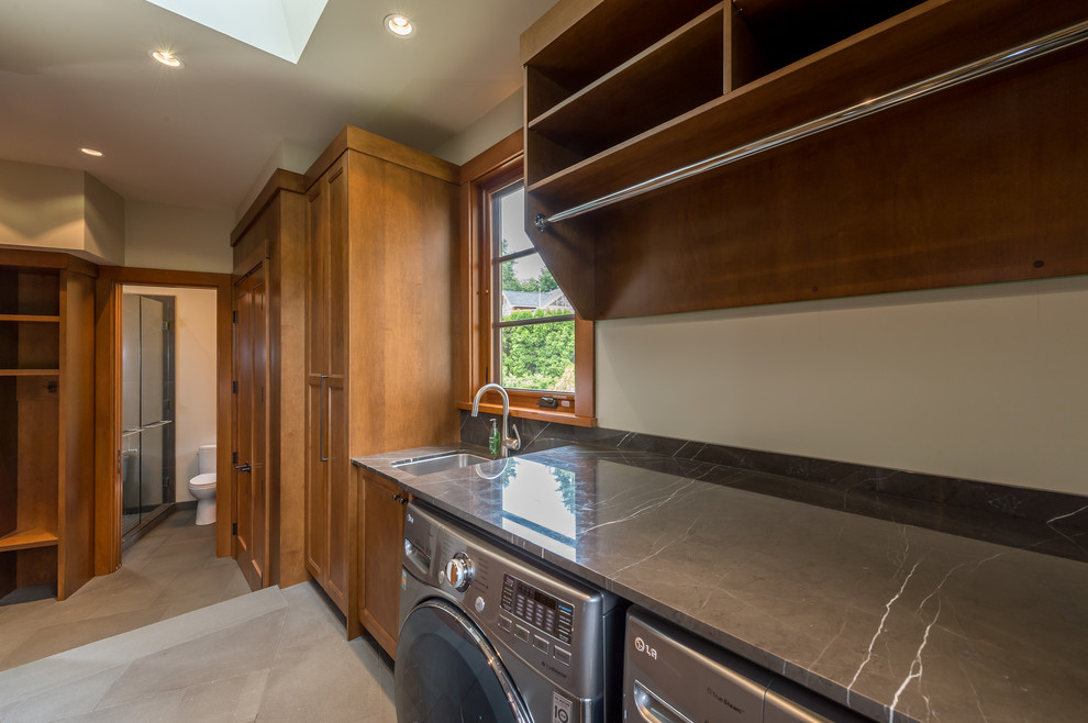 This is an example of a medium sized modern galley utility room in Vancouver with a submerged sink, open cabinets, granite worktops, beige walls, slate flooring, a side by side washer and dryer and medium wood cabinets.
