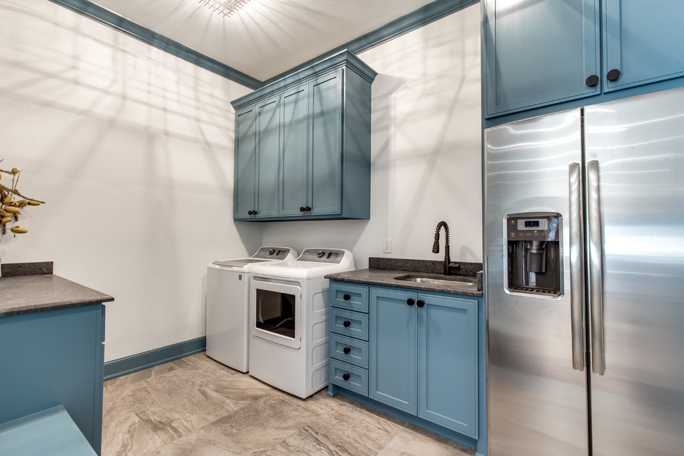 Expansive traditional separated utility room in Oklahoma City with a submerged sink, shaker cabinets, blue cabinets, granite worktops, white walls, ceramic flooring, a side by side washer and dryer and black worktops.