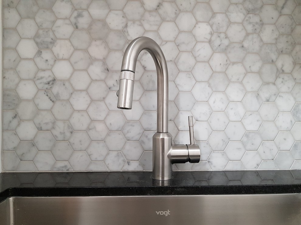 Example of a large transitional single-wall marble floor and white floor dedicated laundry room design in Toronto with an undermount sink, shaker cabinets, white cabinets, quartz countertops and a stacked washer/dryer