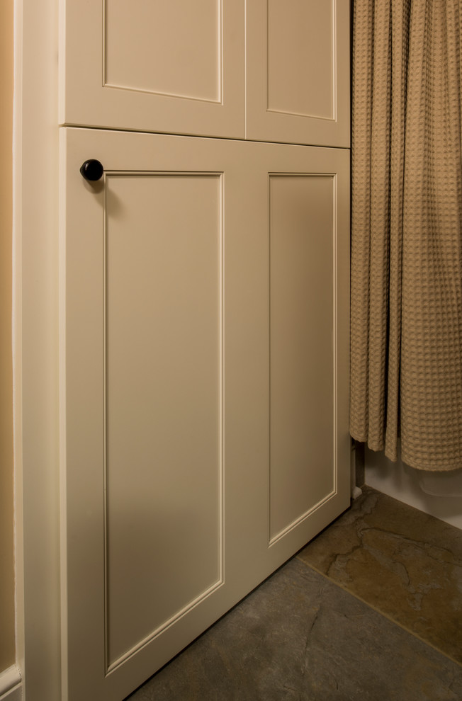 Photo of a small classic single-wall laundry cupboard in Raleigh with recessed-panel cabinets, beige walls, multi-coloured floors, beige cabinets and porcelain flooring.