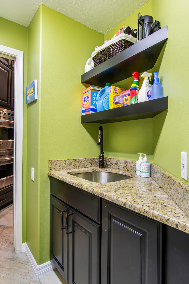 Inspiration for a small transitional galley porcelain tile laundry room remodel in Tampa with an undermount sink, raised-panel cabinets, black cabinets, granite countertops, green walls and a side-by-side washer/dryer