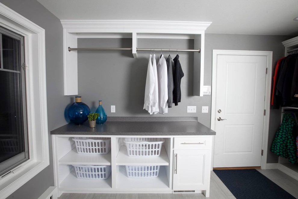 Imagen de lavadero multiusos moderno con armarios con paneles empotrados, puertas de armario blancas, encimera de laminado y paredes grises