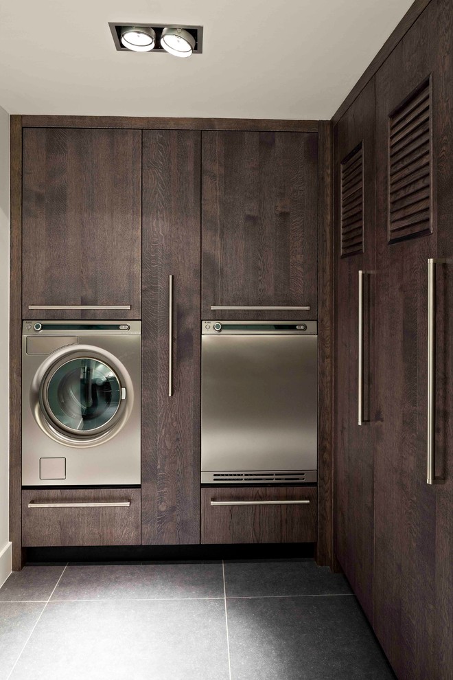 Immagine di una lavanderia design con ante in legno bruno e ante lisce