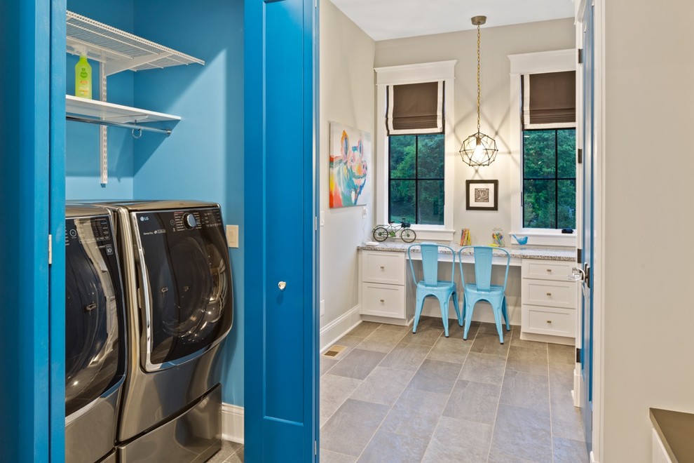 Exempel på en mellanstor klassisk grå parallell grått liten tvättstuga, med skåp i shakerstil, vita skåp, laminatbänkskiva, blå väggar, vinylgolv, tvättmaskin och torktumlare byggt in i ett skåp och grått golv