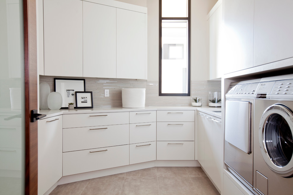 Moderne Waschküche mit flächenbündigen Schrankfronten, weißen Schränken und Waschmaschine und Trockner nebeneinander in Vancouver
