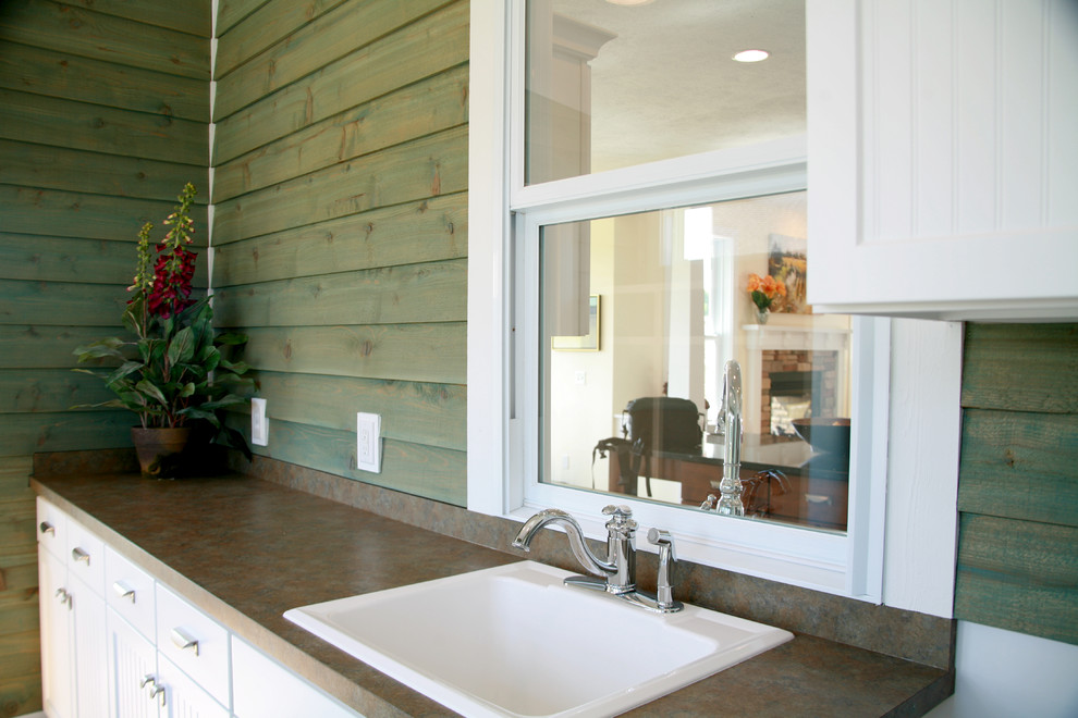 Imagen de cuarto de lavado lineal de estilo americano de tamaño medio con fregadero encastrado, armarios estilo shaker, puertas de armario blancas y paredes verdes