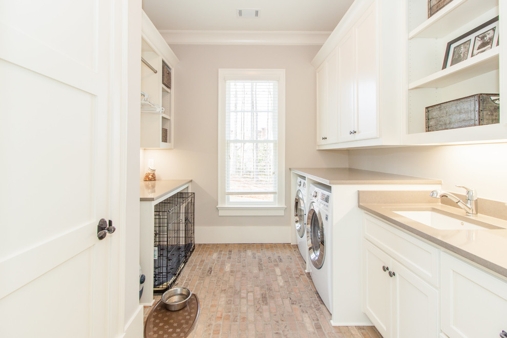This is an example of a classic utility room in Atlanta with flat-panel cabinets and white cabinets.