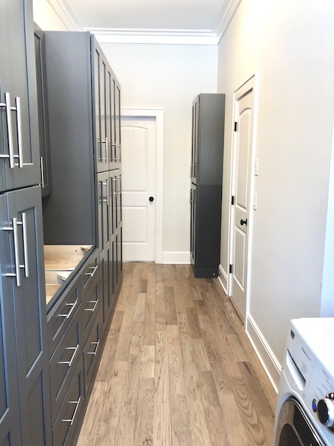 Dedicated laundry room - mid-sized transitional galley light wood floor and beige floor dedicated laundry room idea in Bridgeport with shaker cabinets, gray cabinets, gray walls and a side-by-side washer/dryer
