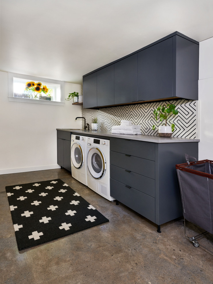 Einzeilige, Mittelgroße Moderne Waschküche mit Unterbauwaschbecken, flächenbündigen Schrankfronten, grauen Schränken, weißer Wandfarbe, Schieferboden, Waschmaschine und Trockner nebeneinander, braunem Boden und grauer Arbeitsplatte in Portland