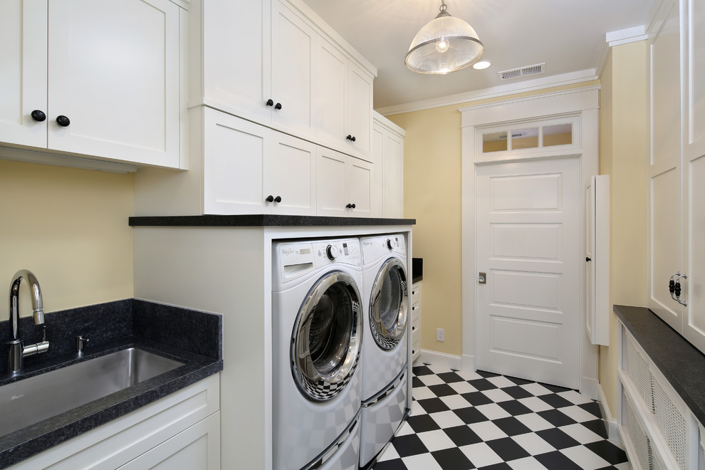 Photo of a large traditional galley separated utility room in San Francisco with a submerged sink, recessed-panel cabinets, white cabinets, granite worktops, beige walls, porcelain flooring, a side by side washer and dryer, multi-coloured floors and black worktops.