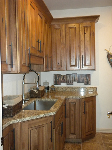 Mittelgroße Klassische Waschküche in L-Form mit profilierten Schrankfronten, hellbraunen Holzschränken, Granit-Arbeitsplatte, beiger Wandfarbe und Waschmaschine und Trockner nebeneinander in Denver