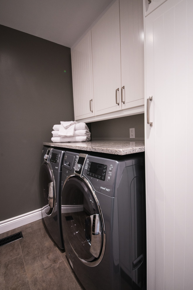This is an example of a contemporary galley utility room in Ottawa with a submerged sink, raised-panel cabinets, white cabinets, engineered stone countertops, multi-coloured splashback and porcelain splashback.