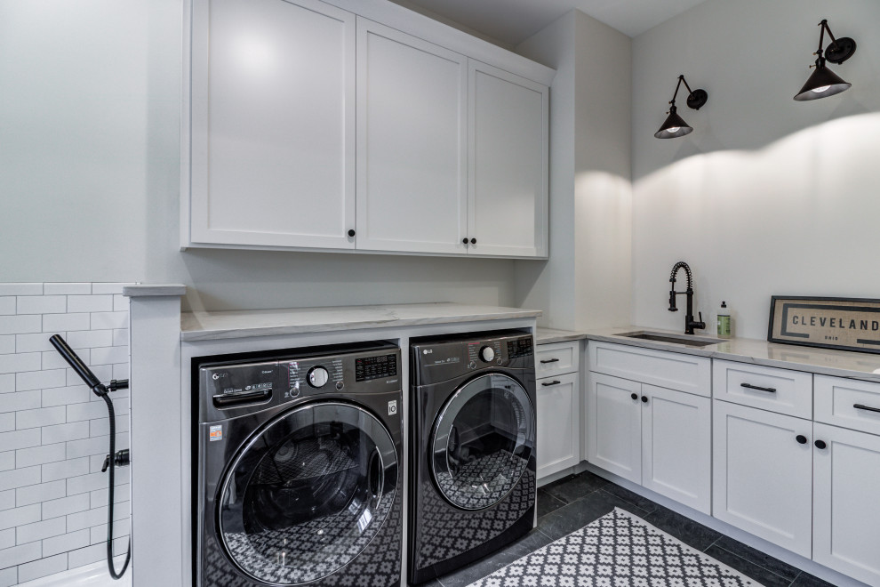 Idéer för vintage l-formade grått tvättstugor enbart för tvätt, med en undermonterad diskho, skåp i shakerstil, vita skåp, bänkskiva i kvartsit, grå väggar, skiffergolv, en tvättmaskin och torktumlare bredvid varandra och grått golv