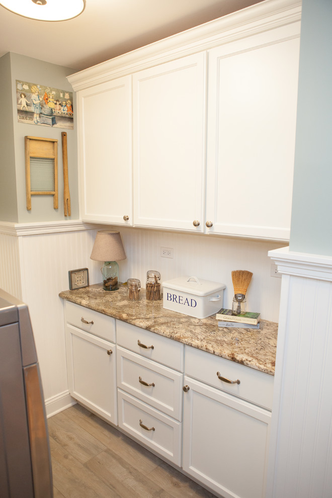 Design ideas for a small classic u-shaped separated utility room in Chicago with recessed-panel cabinets, white cabinets, granite worktops, blue walls, medium hardwood flooring and a side by side washer and dryer.