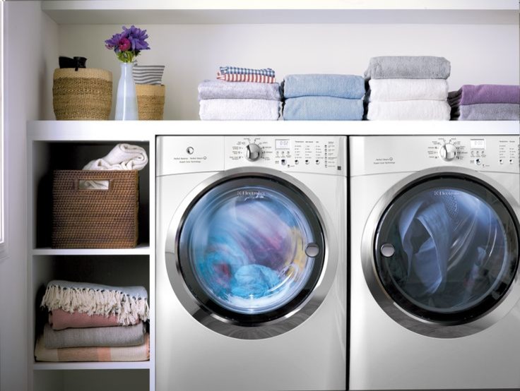 Immagine di una piccola sala lavanderia moderna con lavatrice e asciugatrice affiancate, nessun'anta, ante bianche, top in superficie solida e pareti bianche