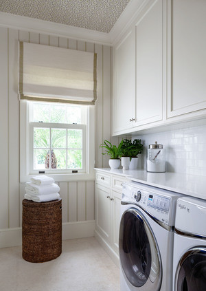 Exempel på en mellanstor tvättstuga, med luckor med profilerade fronter, vita skåp, flerfärgade väggar och kalkstensgolv