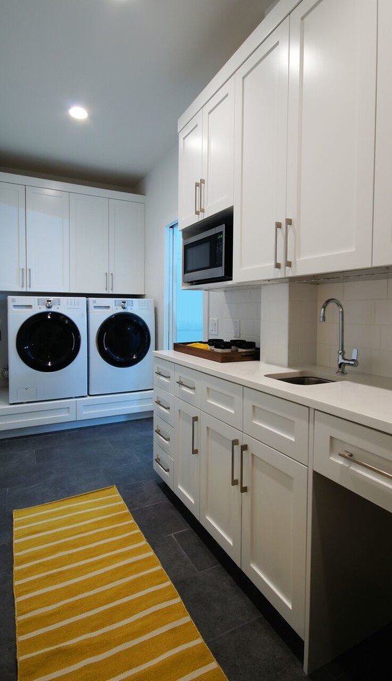 Foto på en funkis linjär tvättstuga, med en undermonterad diskho, skåp i shakerstil, vita skåp, bänkskiva i koppar, vita väggar, klinkergolv i porslin och en tvättmaskin och torktumlare bredvid varandra