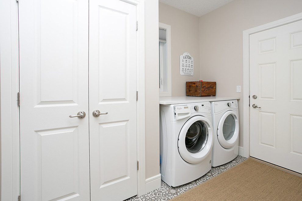 Design ideas for a medium sized traditional single-wall utility room with beige walls and a side by side washer and dryer.