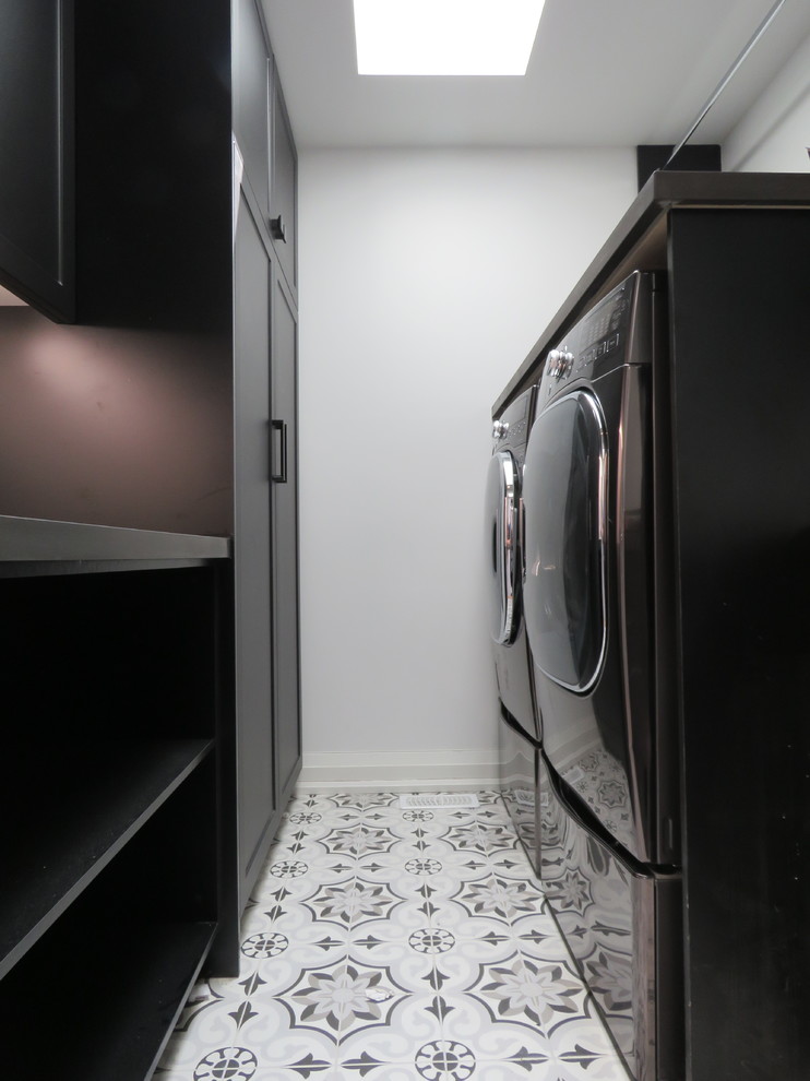 Foto di una sala lavanderia minimalista di medie dimensioni con lavello da incasso, ante lisce, ante nere, top in granito, pareti bianche, pavimento con piastrelle in ceramica, lavatrice e asciugatrice affiancate, pavimento multicolore e top nero