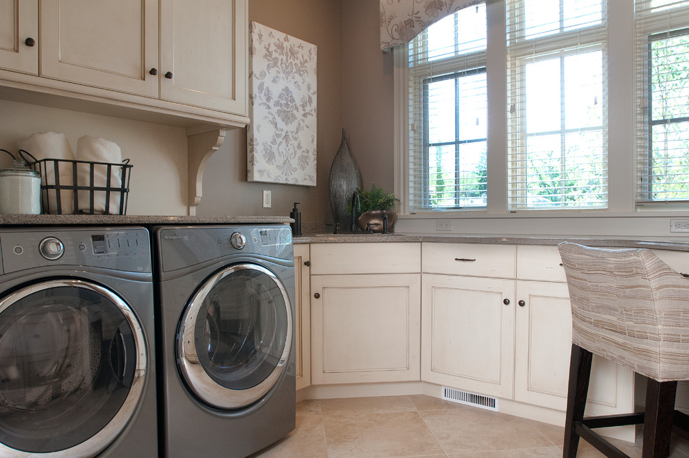 Bild på ett mellanstort medelhavsstil u-format grovkök, med luckor med infälld panel, vita skåp, grå väggar och en tvättmaskin och torktumlare bredvid varandra