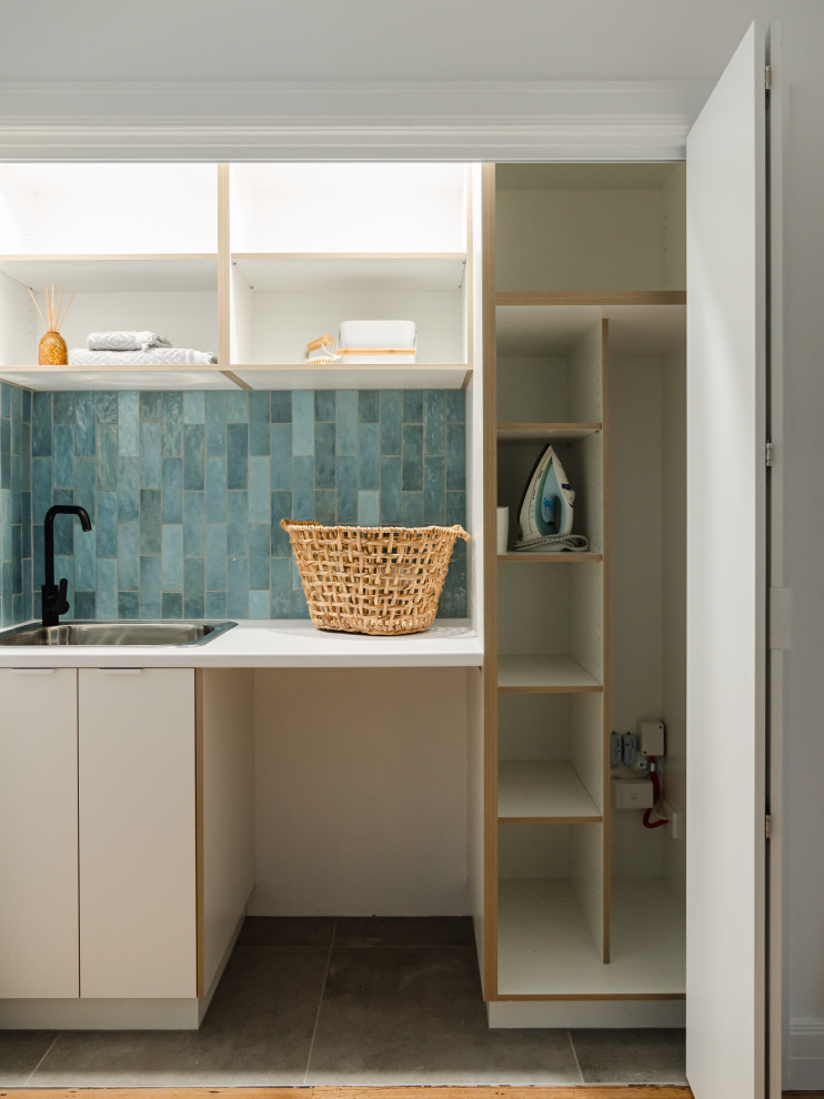 Inspiration for a retro utility room in Melbourne with a single-bowl sink, white cabinets, laminate countertops, blue splashback, metro tiled splashback, blue walls, porcelain flooring, grey floors and white worktops.