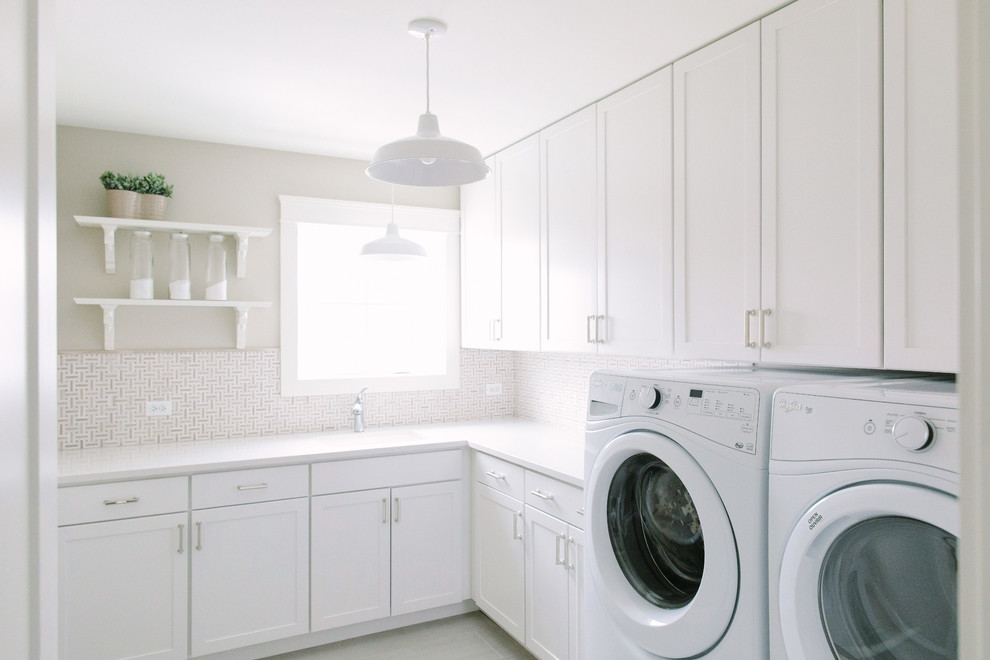 Idéer för lantliga l-formade tvättstugor enbart för tvätt, med skåp i shakerstil, vita skåp, beige väggar och en tvättmaskin och torktumlare bredvid varandra