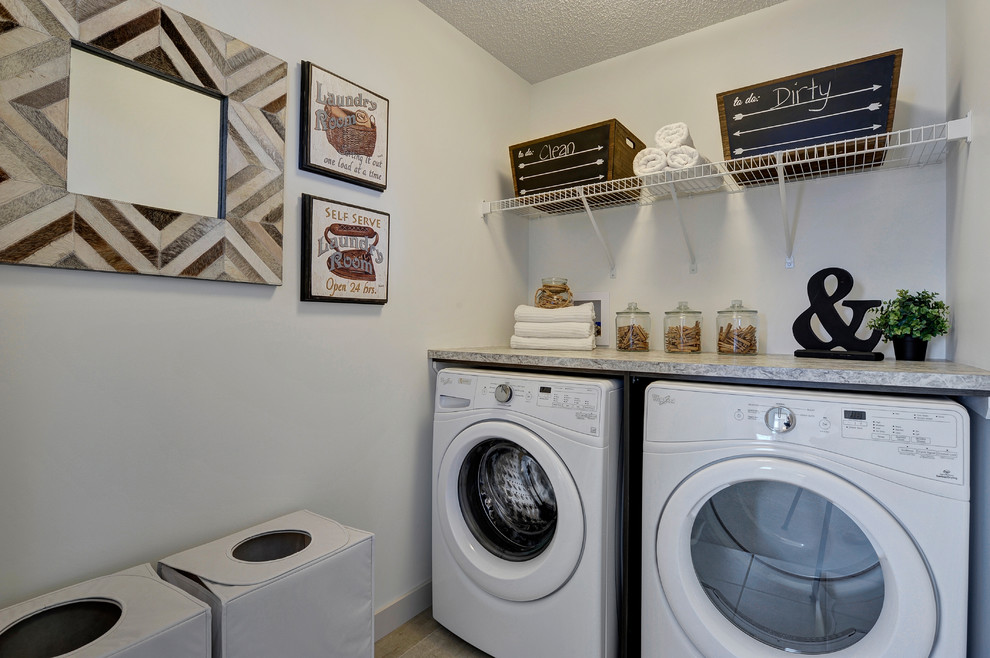 Diseño de cuarto de lavado lineal clásico renovado de tamaño medio con encimera de laminado, paredes blancas, suelo de baldosas de cerámica, lavadora y secadora juntas y suelo beige