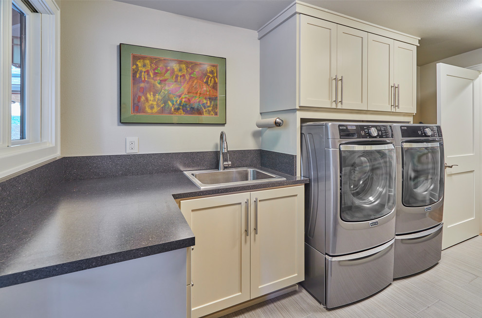 This is an example of a contemporary l-shaped separated utility room in Other with an utility sink, grey walls, a side by side washer and dryer, grey floors and grey worktops.
