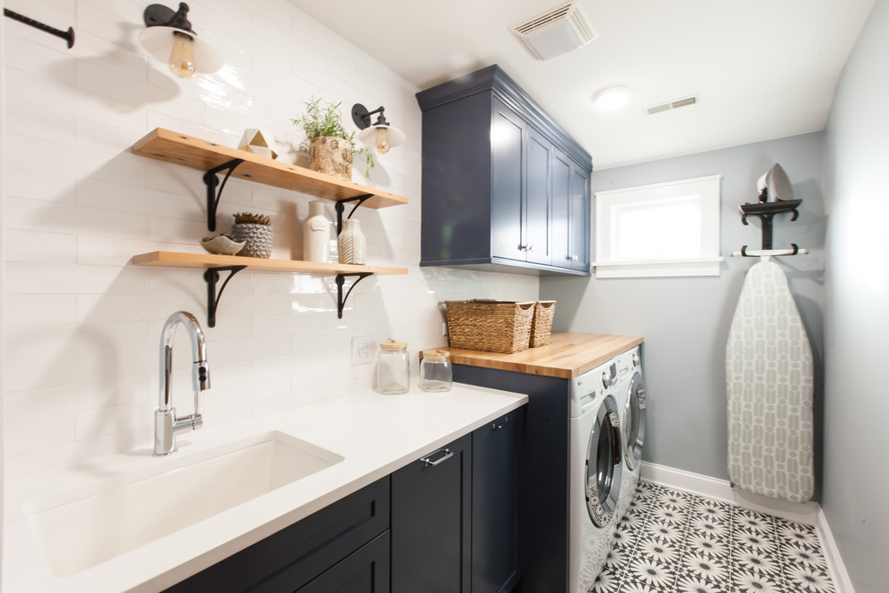 Idéer för att renovera en mellanstor funkis vita linjär vitt tvättstuga enbart för tvätt, med en undermonterad diskho, skåp i shakerstil, blå skåp, bänkskiva i kvarts, blå väggar, betonggolv, en tvättmaskin och torktumlare bredvid varandra och blått golv
