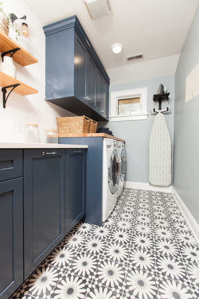 Foto på en mellanstor funkis vita linjär tvättstuga enbart för tvätt, med en undermonterad diskho, skåp i shakerstil, blå skåp, bänkskiva i kvarts, blå väggar, betonggolv, en tvättmaskin och torktumlare bredvid varandra och blått golv