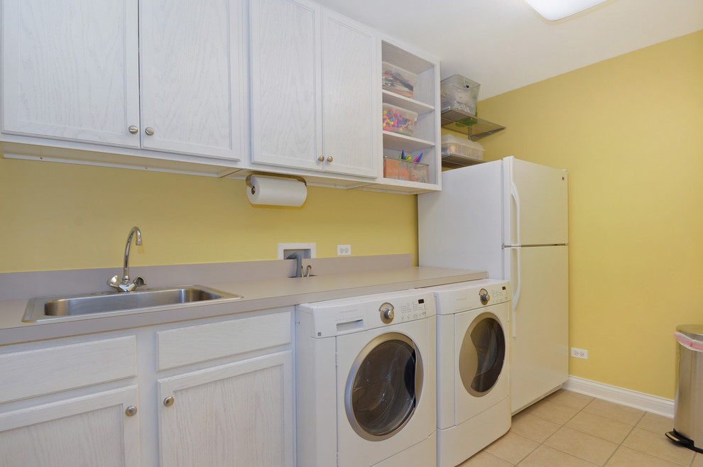 Immagine di una lavanderia multiuso minimal di medie dimensioni con top in laminato